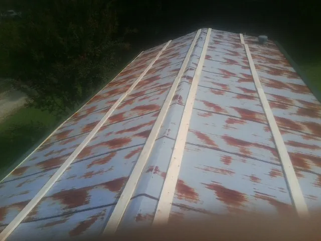 Rusted metal roof panels with new wood purlins before replacement — Storm Damage Roof Repair in Wyola by Roofing Brothers